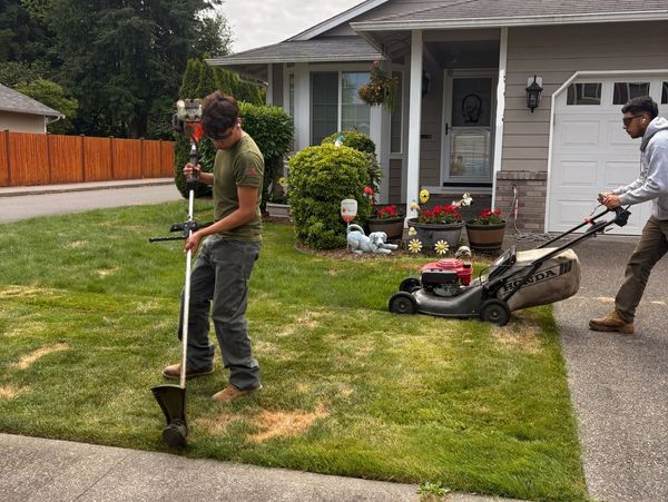 Employees mowing and edging customer property. 