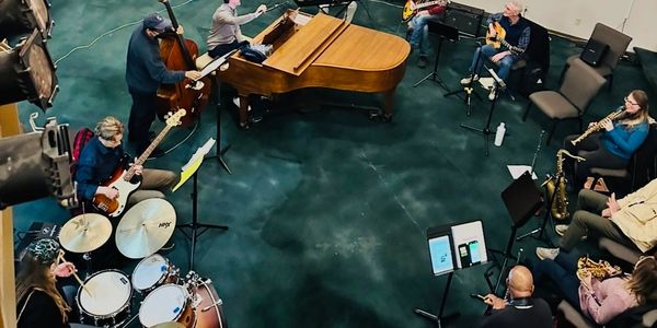 A jazz band rehearsing with various instruments in a spacious room.