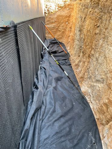 Footer drain system completely wrapped in Mirfi fabric.  Dimple matt on foundation for water channel