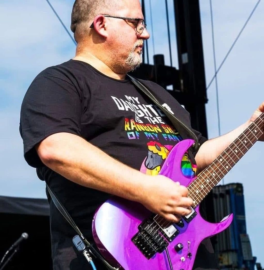 Man playing a purple electric guitar.