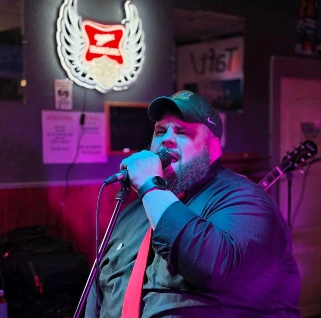 Man singing passionately in a dimly lit bar.