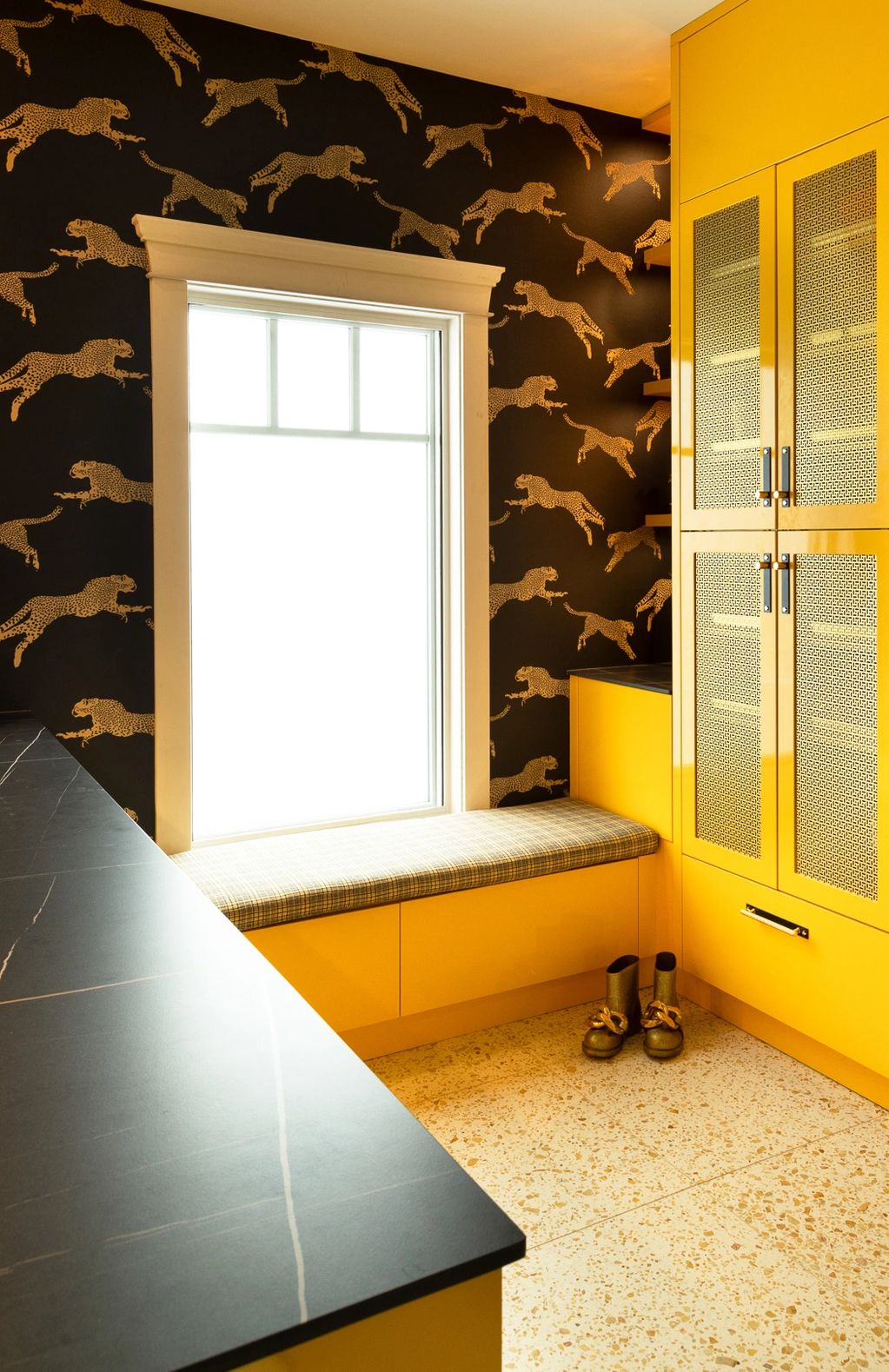 Yellow high gloss cabinetry with gold metal inserts. Custom bench