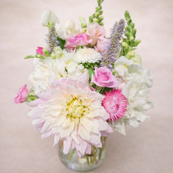 Delicate pastel floral bouquet in a clear glass vase.