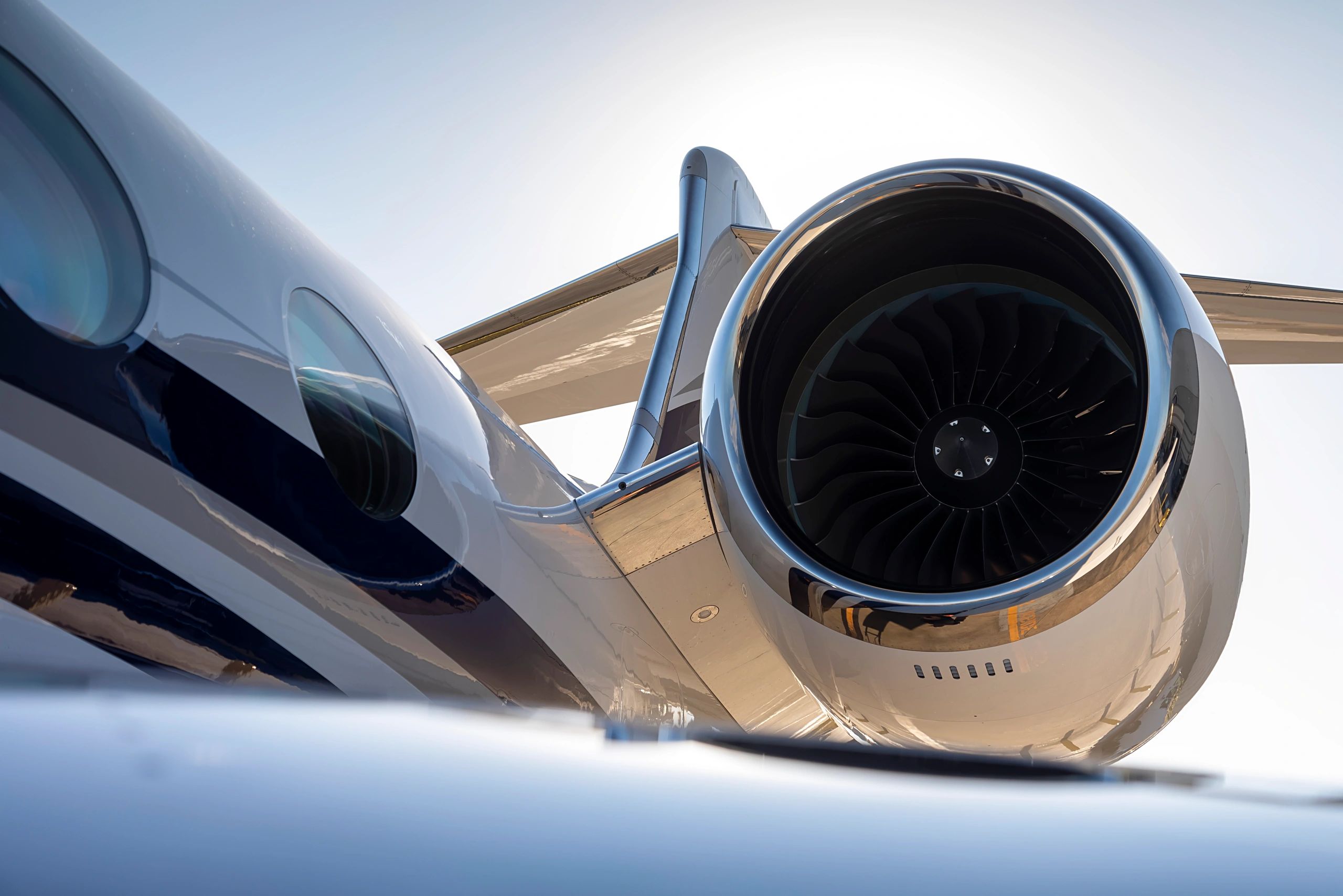 Close-up of a sleek jet engine on a private airplane wing.