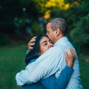 man and woman cuddling in a garden