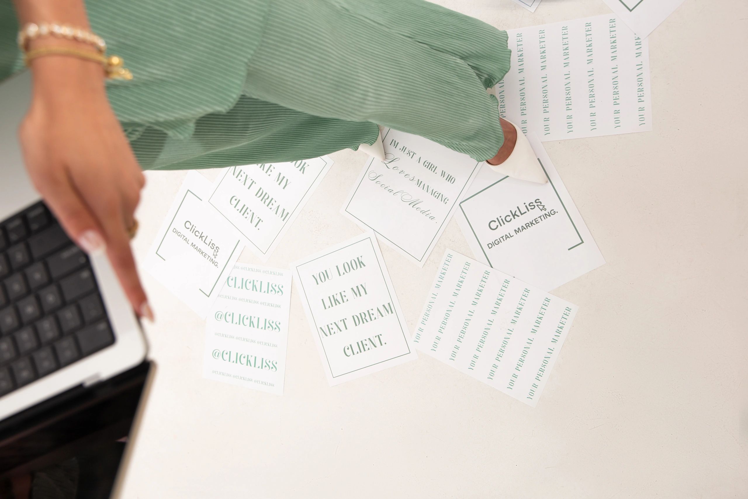 Person in a green outfit examining marketing cards on the floor.