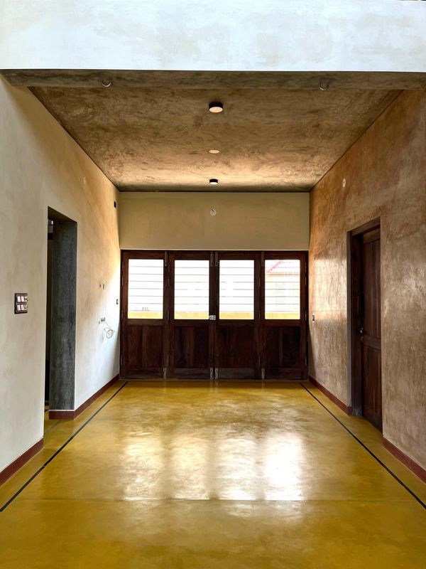 Room with yellow floor, wooden doors, and textured walls.