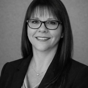 Professional woman with glasses smiling.