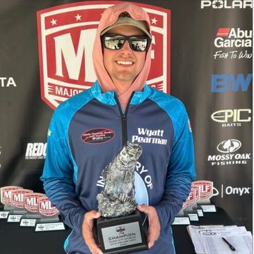 Man holding a fishing trophy and smiling.