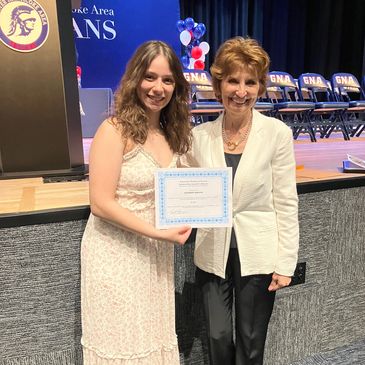 Young woman receiving certificate at school event.