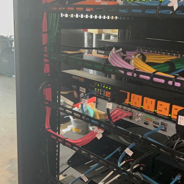 Organized server rack with labeled network cables and power strips.
