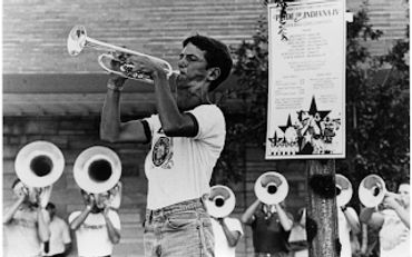 Young trumpet player performing in an outdoor band rehearsal.