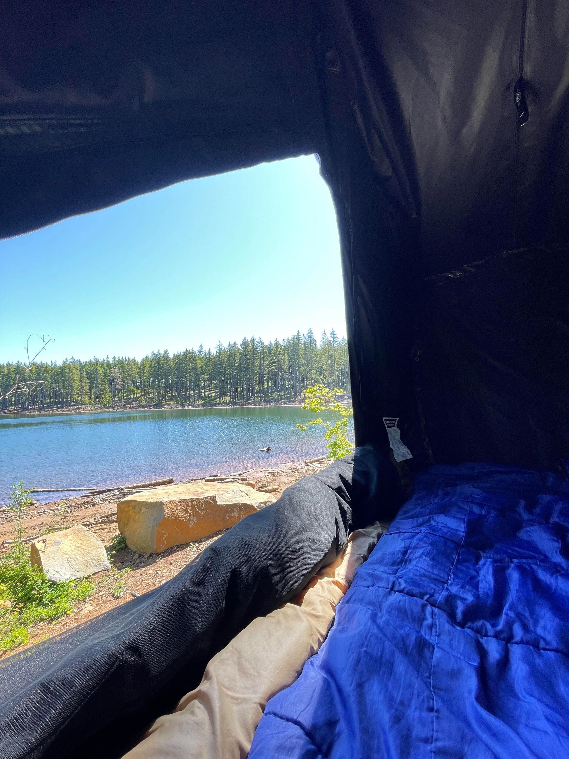 camping in a roof top tent with a view of a lake 