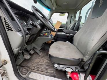Interior view of a truck cabin showing driver's seat and dashboard.