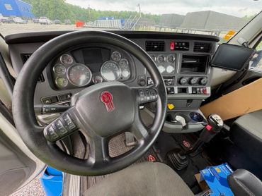 Interior view of a truck cabin with steering wheel and dashboard.