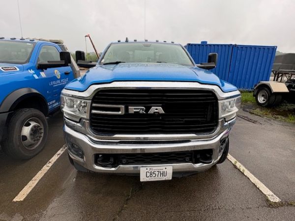 Front view of a blue RAM truck parked on a wet day.