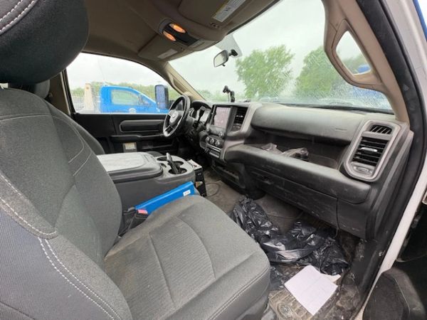 Interior of a truck cabin showing seats, dashboard, and clutter on the floor.