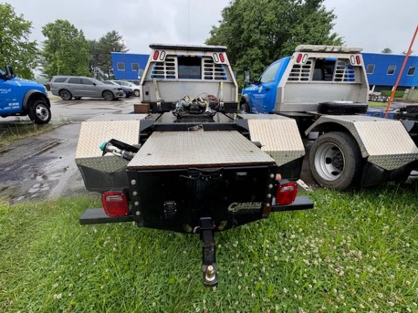 Rear view of two industrial truck chassis with diamond-plate surfaces.