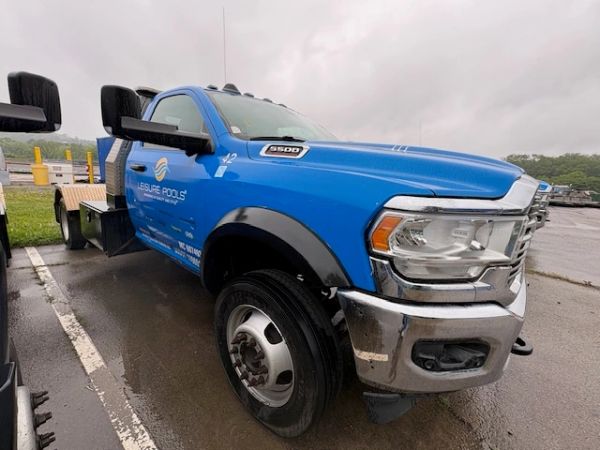 Blue Leisure Pools service truck parked on a wet driveway.