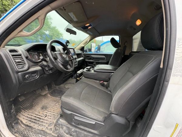 Interior view of a car showing the front seats and dashboard with some dirt on the floor mats.