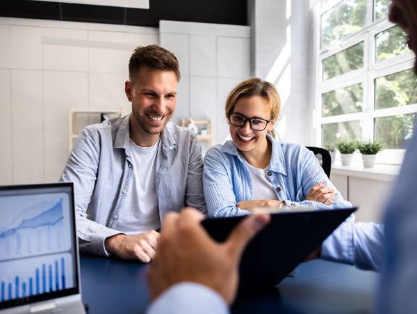 Financial consultant explaining new project investment to young couple in office 