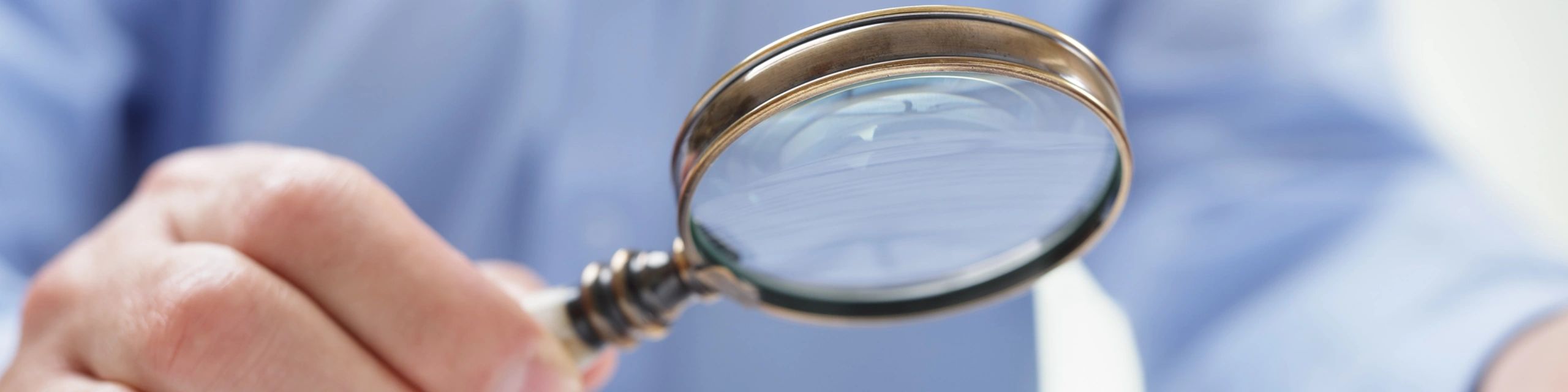 Person holding a magnifying glass.
