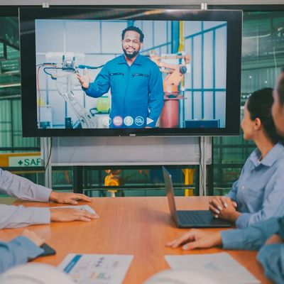 Industrial training session with workers learning from a supervisor on screen in a BC facility.