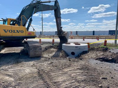 Volvo excavator working on a construction site under a blue sky.