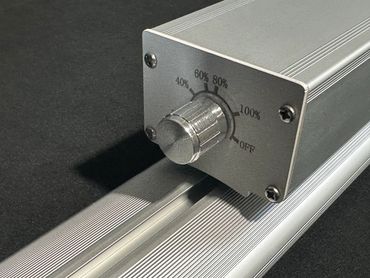 Close-up of a metallic knob with percentage settings on a silver device.