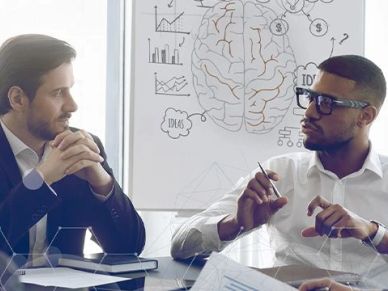 Two men discussing ideas with brain diagram in the background.