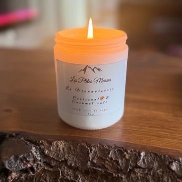 Bougie parfumée allumée sur une table en bois.
