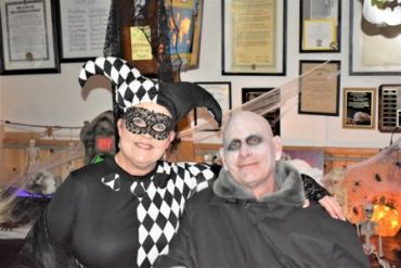 Couple in Halloween costumes posing indoors.