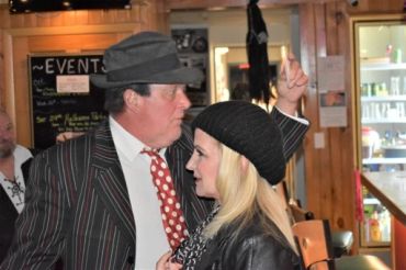 Two people in vintage-style attire at an indoor event.