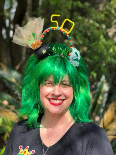 Woman with green wig and St. Patrick's Day themed hat.
