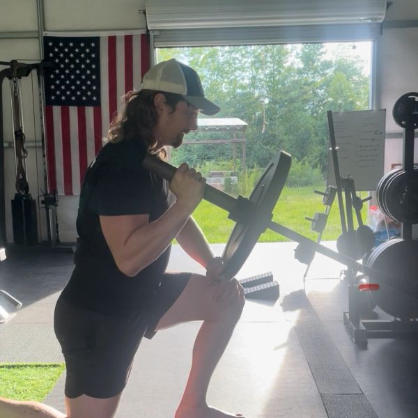 Man exercising with barbell in gym.