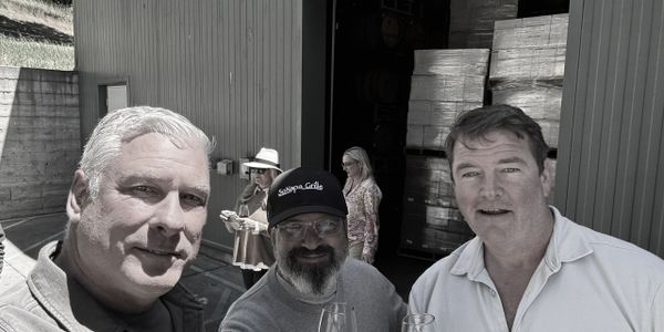 Three men enjoying a casual outdoor gathering with drinks.