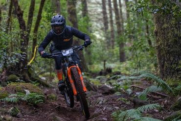 Bicycle race and racer. Overhaul tune for bike races in the PNW. Loam, ferns, helmet, bike race