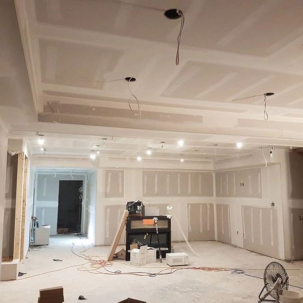 Room under construction with drywall and exposed wiring.