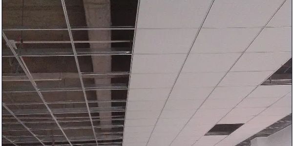 Ceiling under construction with exposed and installed panels.