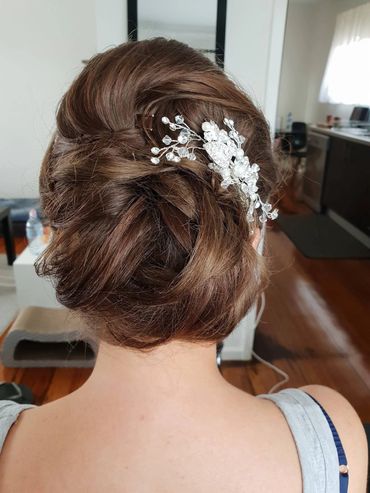 Elegant updo hairstyle with a decorative hair accessory.