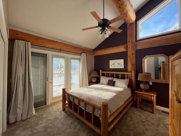 Main floor master bedroom with queen bed.  French doors opening onto south facing deck.