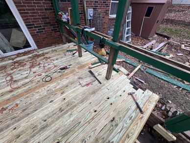 New wooden deck under construction with tools scattered.