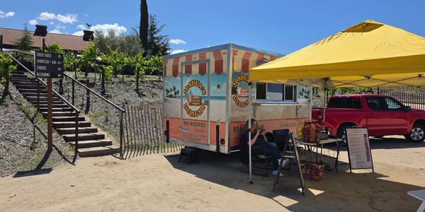 Food truck setup with a yellow canopy on a sunny day.