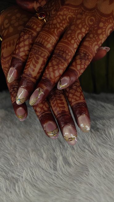 Hands with intricate henna and decorated nails.