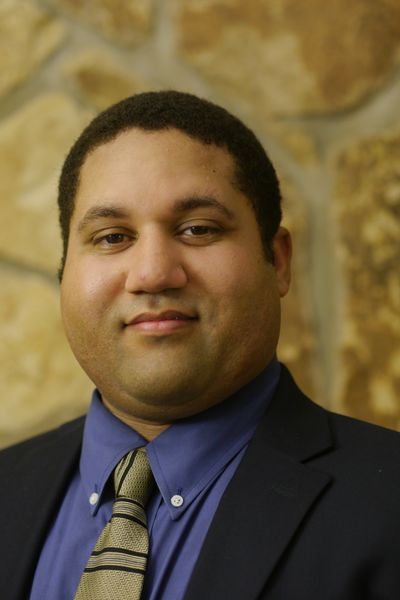 Professional man in suit and tie with stone wall background.