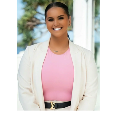 Confident woman smiling in a pink top and white blazer.
