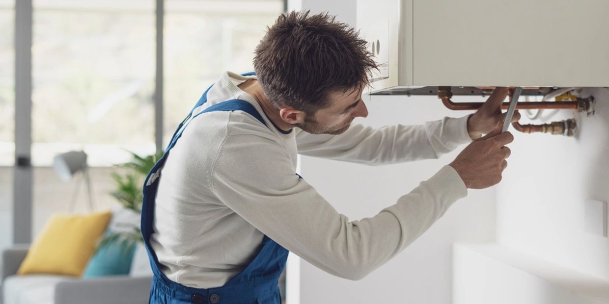 Professional plumber checking a boiler and pipes, boiler service concept