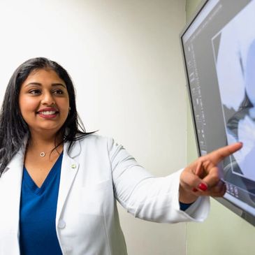 Dr. Gundarpi Showing a patient their teeth x-ray at Arlington Dental Clinic