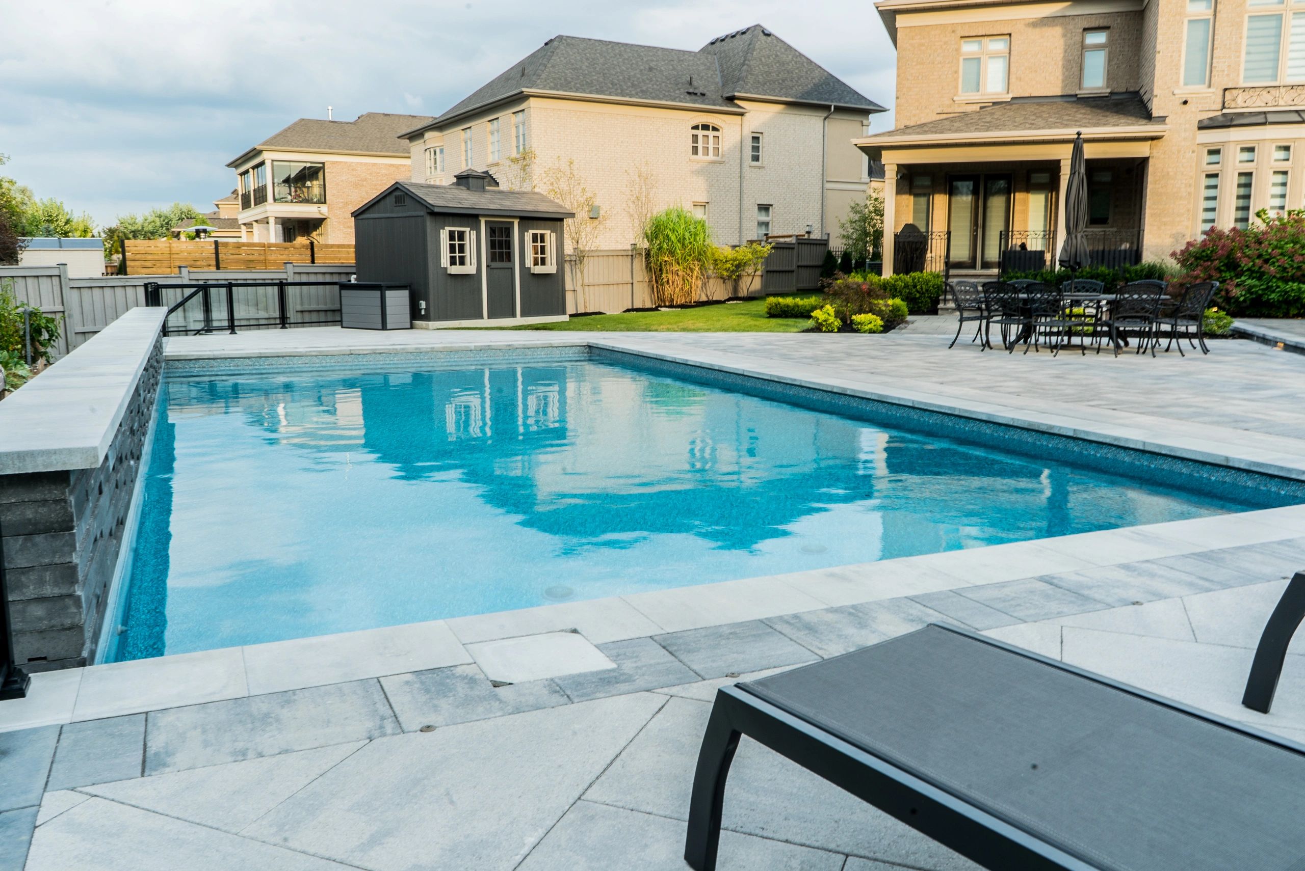 Modern backyard with a clean pool and patio seating.