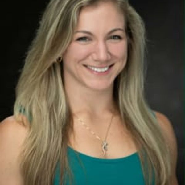 Smiling woman with long blonde hair wearing a teal top.